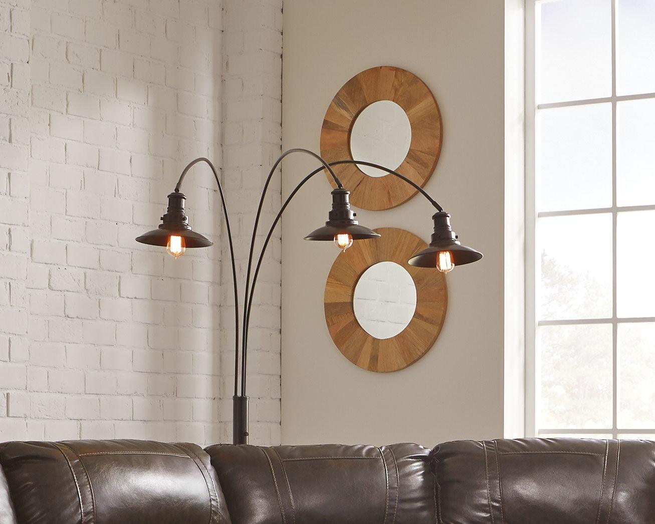 Side view of Sheriel Black Metal Arc Floor Lamp illuminating living room corner