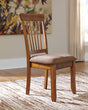 Berringer Brown Upholstered Wood Dining Chair front view showing spindle back and cushioned seat