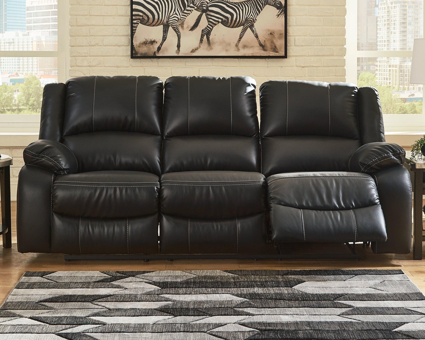 Calderwell Black Faux Leather Reclining Sofa - Ella Furniture