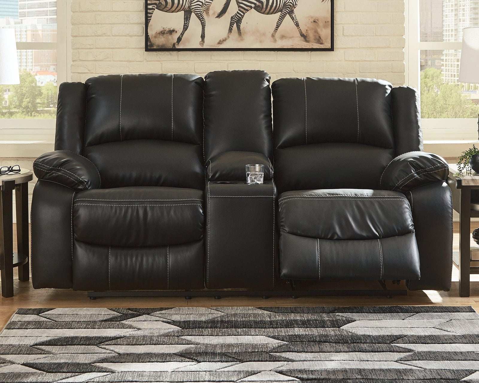 Calderwell Black Faux Leather Reclining Loveseat With Console - Ella Furniture